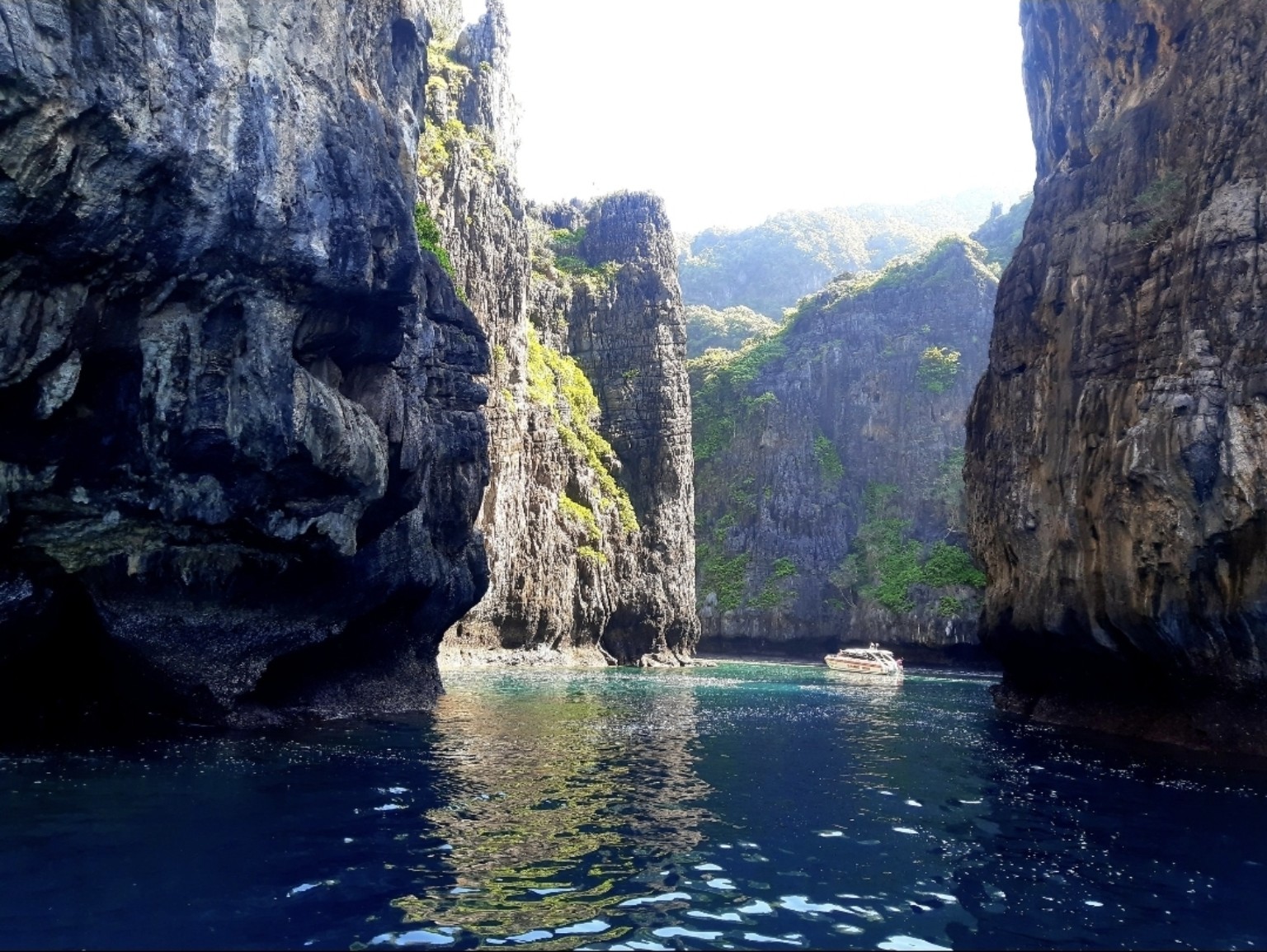 Towering limestone cliffs and sheltered turquoise waters in Phi Phi, photographed by Phuket Island Charters